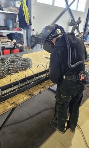 Suvirintojas dirbtuvėse ruošia armatūros konstrukciją